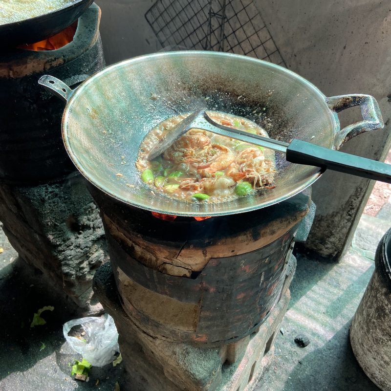กระทะบนเตาถ่านดินในครัวของร้าน